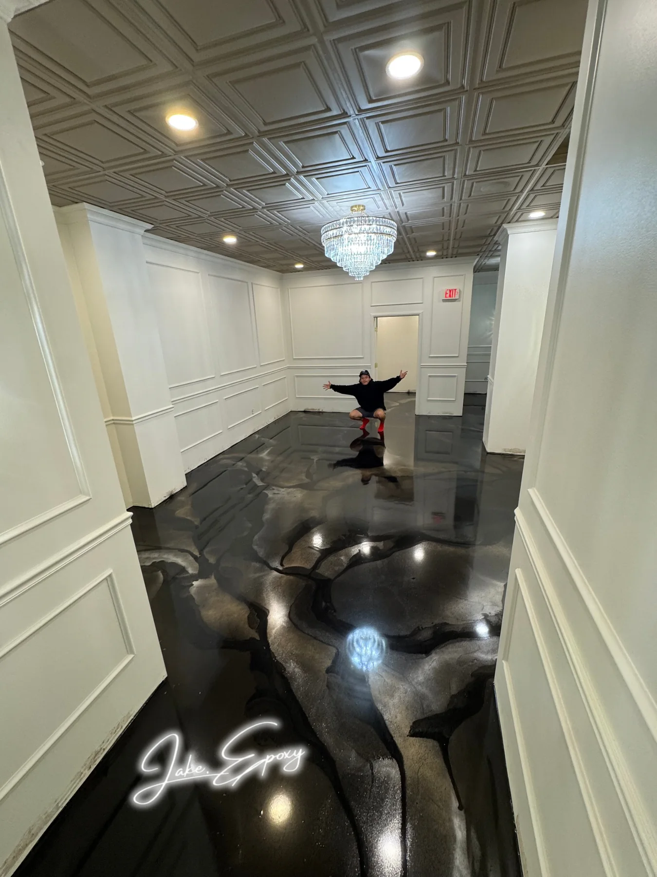 Black metallic epoxy floor with chandelier reflection